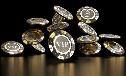 Golden and carbon VIP poker chips on a dark background