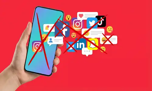 An illustration of a smartphone with social media icons crossed out by a ban symbol on a red background