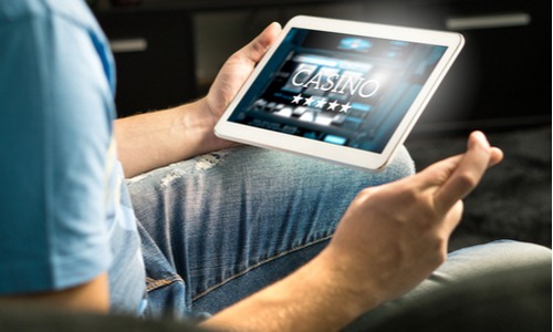 man playing online casino games on tablet
